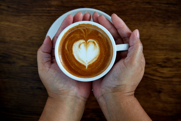 istock Hands holding coffee cup,heart on coffee cup and woman nails 1084430586