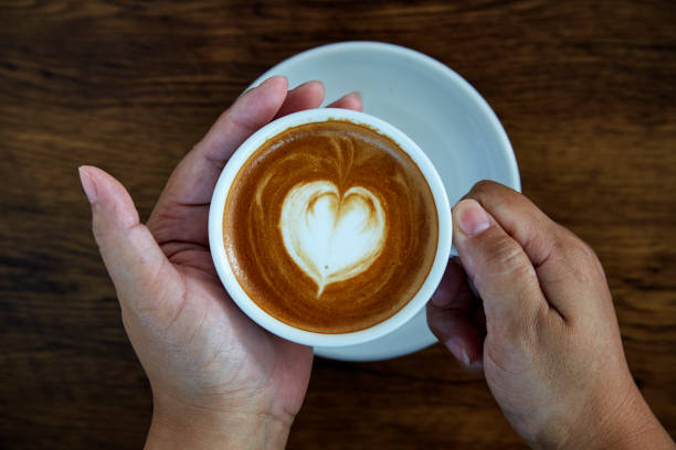 istock Hands holding coffee cup,heart on coffee cup and woman nails 1084430610