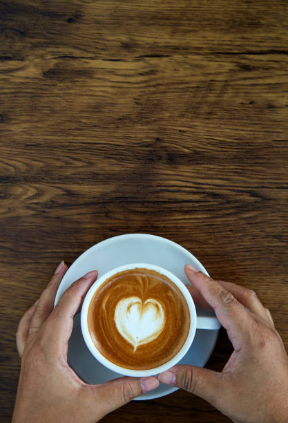 istock Hands holding coffee cup,heart on coffee cup and woman nails 1084430654
