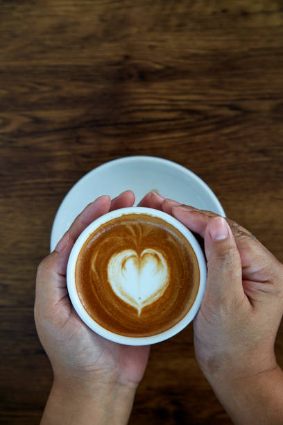 istock Hands holding coffee cup,heart on coffee cup and woman nails 1084430736