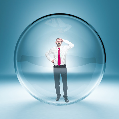 caucasian businessman standing in a glass bubble