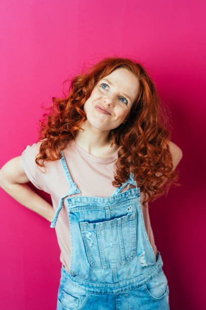istock Young woman with wry face on pink background 1084440194