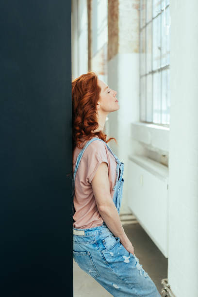 istock Young redhead woman in dungarees 1084440456