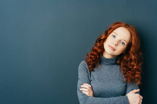 istock Young cute red-haired woman on dark background 1084440782