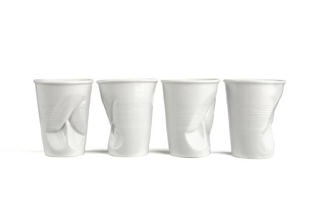 Four funny white ceramic empty coffee cups.