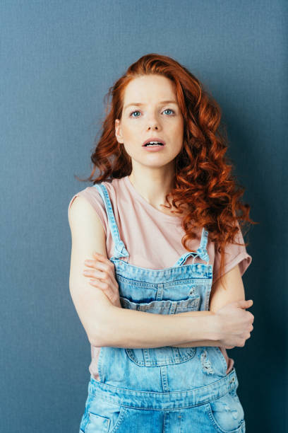 istock Attentive young redhead woman in dungarees 1084446690
