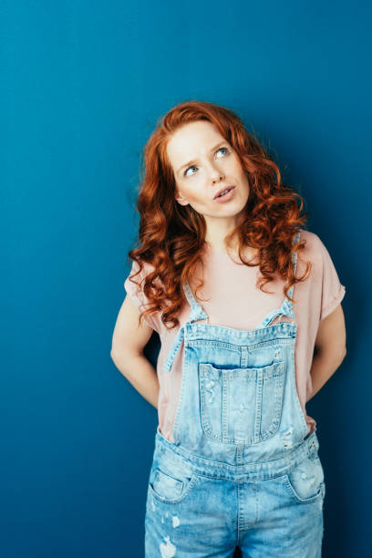 istock Thoughtful young woman in designer dungarees 1084448160