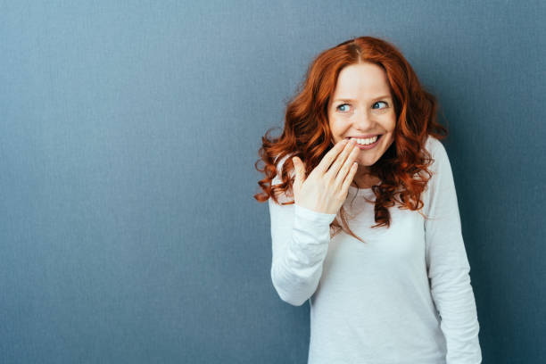 istock Cute young woman laughing behind her hand 1084450156