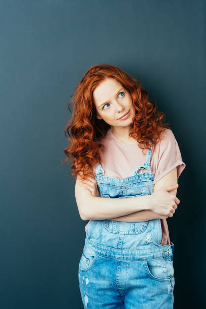 istock Pretty contented young woman standing thinking 1084451390