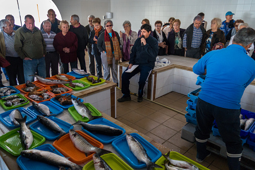 The fish auction has started and the man with the micro is singing the prizes, going down until someone stops him. Everything is in valencian, the local language, and it's difficult to understand because he talks really quickly, but most of the people are neighbours.