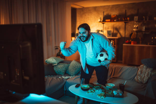 istock Overweight man watching a soccer match 1084453658