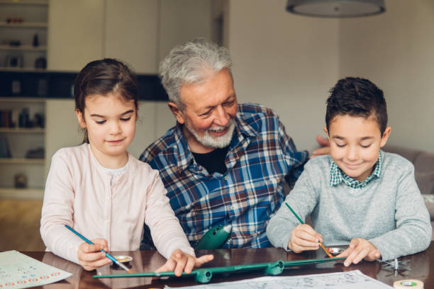istock Man looking at grandchildren assembling a toy 1084454972