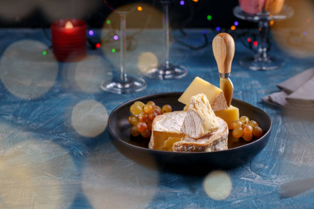 istock Cheese plate on holiday table. Cheese and wine, festive decorations. 1084455740