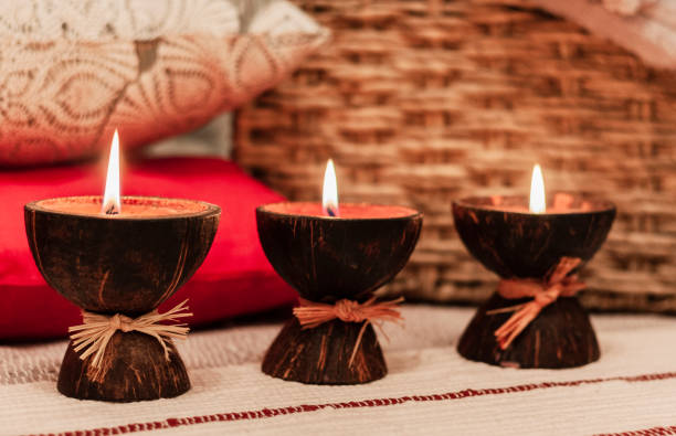 istock Burning spa aroma candles in coconut shell, pillows and plaid, cozy home interior background 1084457798