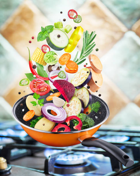 istock Flying fresh vegetables and spices falling into a pan. 1084461222