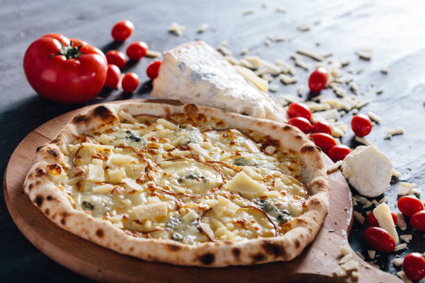 istock Four cheese pizza on wooden board. 1084462520