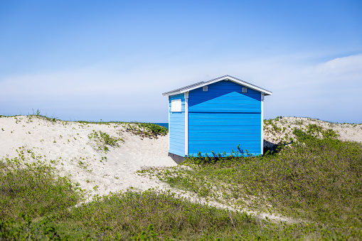 Tisvilde, Denmark - April 29, 2018: A Blue wooden beach huts in the sand dunes at Tisvilde beach