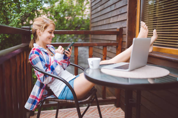 istock Smiling woman on summer vacation using smartphone 1084478928