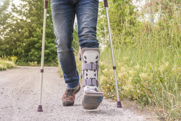Man is running with an orthosis and walking aids on a dirt road orthopedic tools tibia photos stock pictures, royalty-free photos & images