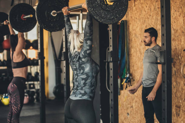 istock Girls weightlifting and personal trainer is watching them 1084486190