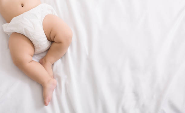 baby legs and bottom in diaper on bed - starting at the bottom imagens e fotografias de stock