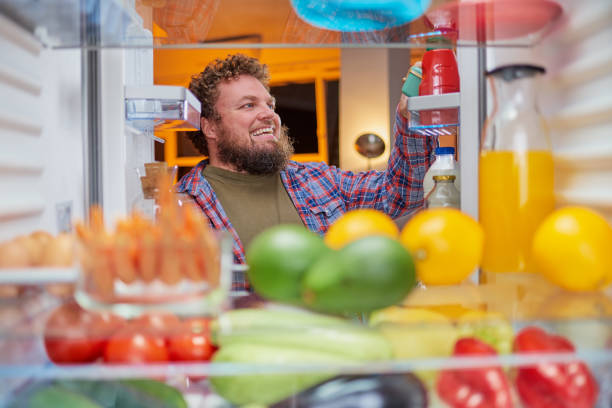 istock Man looking for something to eat at night. 1084486518