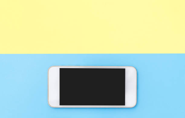 istock Empty mobile phone gadgets on blue and yellow top view flat lay 1084488106