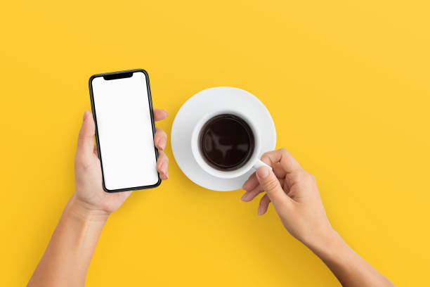 istock Woman holding mobile phone and coffee cup 1084491178