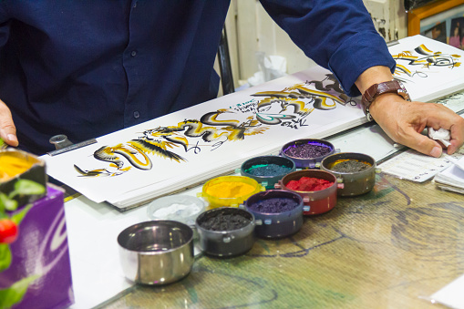 Sydney, Australia - January 20, 2019: Artist painting in a traditional Japanese technique Sumi-e at Paddys Markets in Sydney, Australia. 

Markets are specialise in the sale of fruit, vegetables, fish, clothes and giftware. Paddy Market is located on Hay market in Sydney.