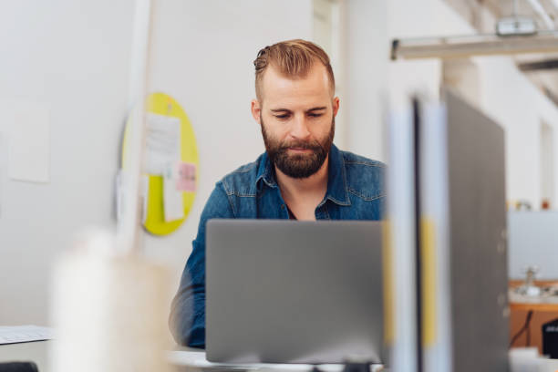 istock Young, urban man on laptop in modern office 1084494132