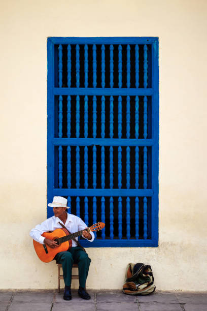 Hispanic Female Musician With A Guitar On A street