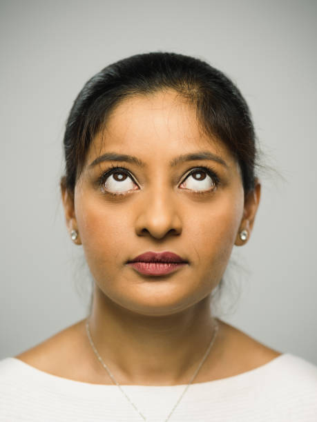 istock Real indian young woman with blank expression looking up 1084498302