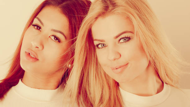 Family relationships, friendship concept. Happy two beautiful women sisters, blonde and brunette having fun.
