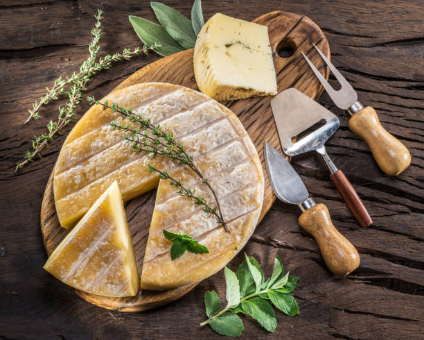istock Cheese wheel with herbs and cutlery. 1084508904