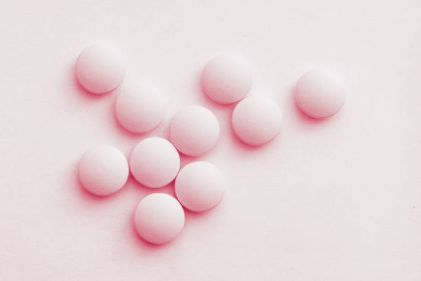 istock Medication pills. White pills, white background 1084515806