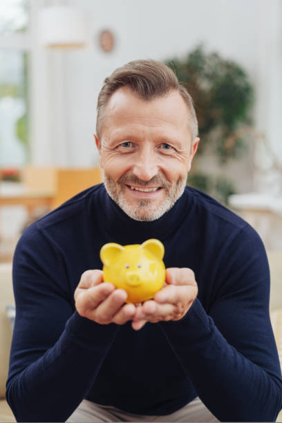 istock Happy middle-aged man with piggy bank 1084515954