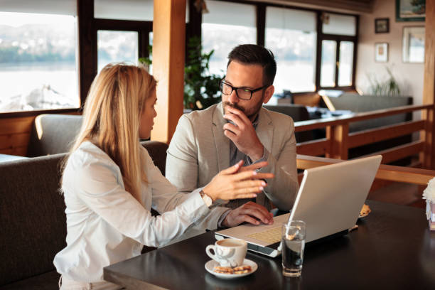 due giovani partner commerciali di sesso maschile e femminile che si incontrano in un bar - discussion coffee cafe coffee shop foto e immagini stock