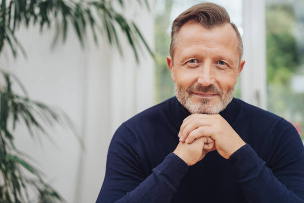 istock Man looking at camera with hands to his chin 1084517232