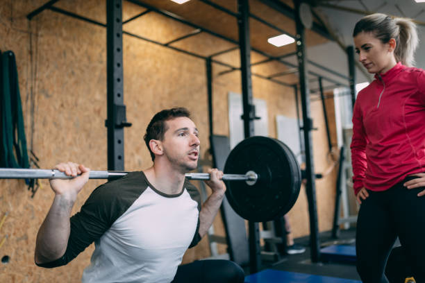 istock Coach showing his client how to squat properly 1084517354
