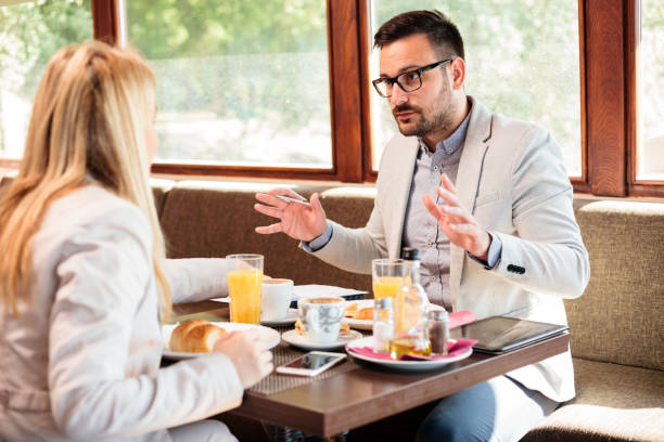 deux jeunes mâles et femelles partenaires ayant une réunion au petit déjeuner dans un café - 11705 photos et images de collection