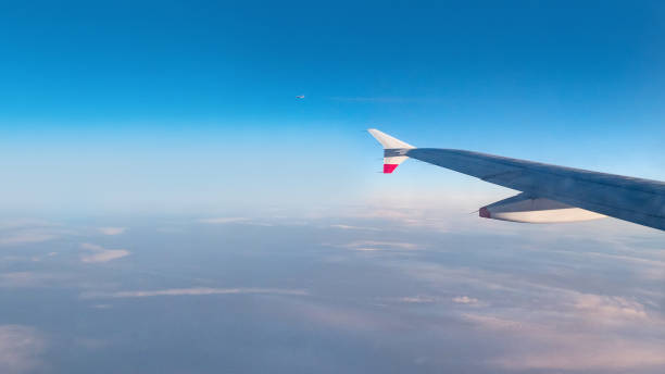 istock Wing of an airplane flying above the morning clouds 1084519692