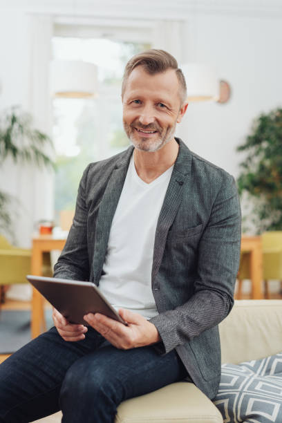 istock Adult man using tablet pc at home 1084520110