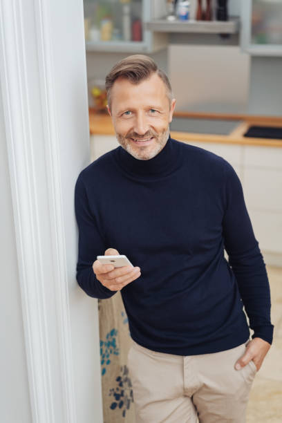 istock Man looking at camera with cellphone in his hand 1084521492