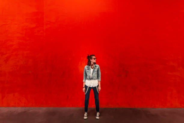 istock Woman walking in front of red background 1084521746