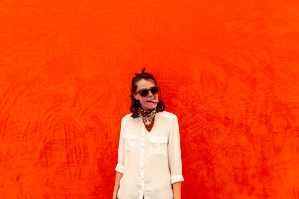 istock Woman making faces on orange and red background 1084521752