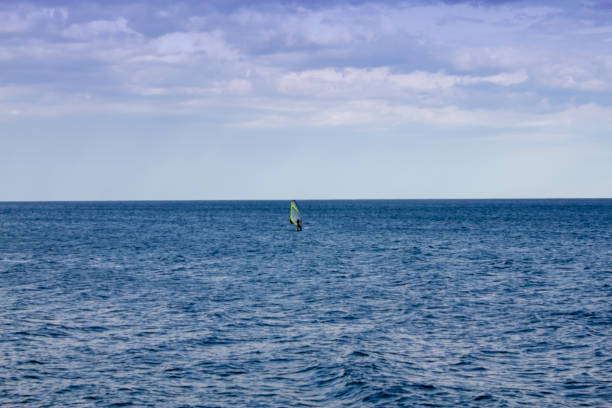 istock Windsurfing. Surfer exercising in calm sea or ocean. 1084523908