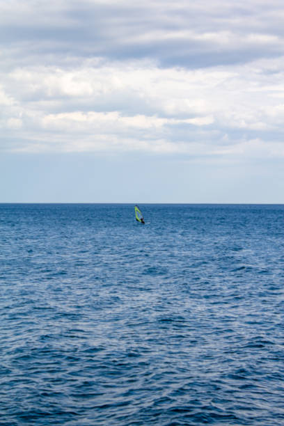 istock Windsurfing. Surfer exercising in calm sea or ocean. 1084524940