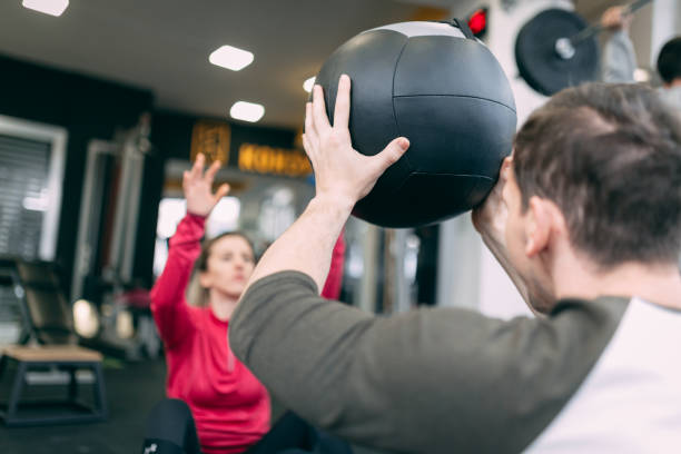 istock Couple doing sit-ups with Medical ball 1084526328