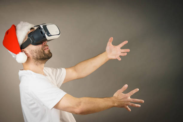istock Man in virtual reality goggles and santa hat 1084530256