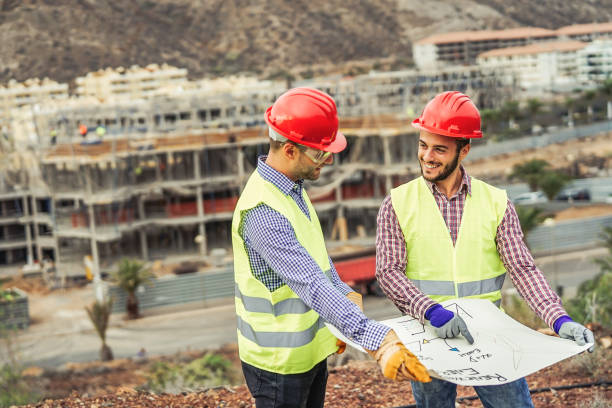 istock Workers engineers discussing about the new building area - Young builders reading the project in the construction site - Teamwork, carpentry, engineering concept 1084532756